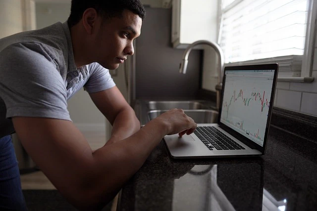 Hombre mirando un gráfico de Forex en una computadora